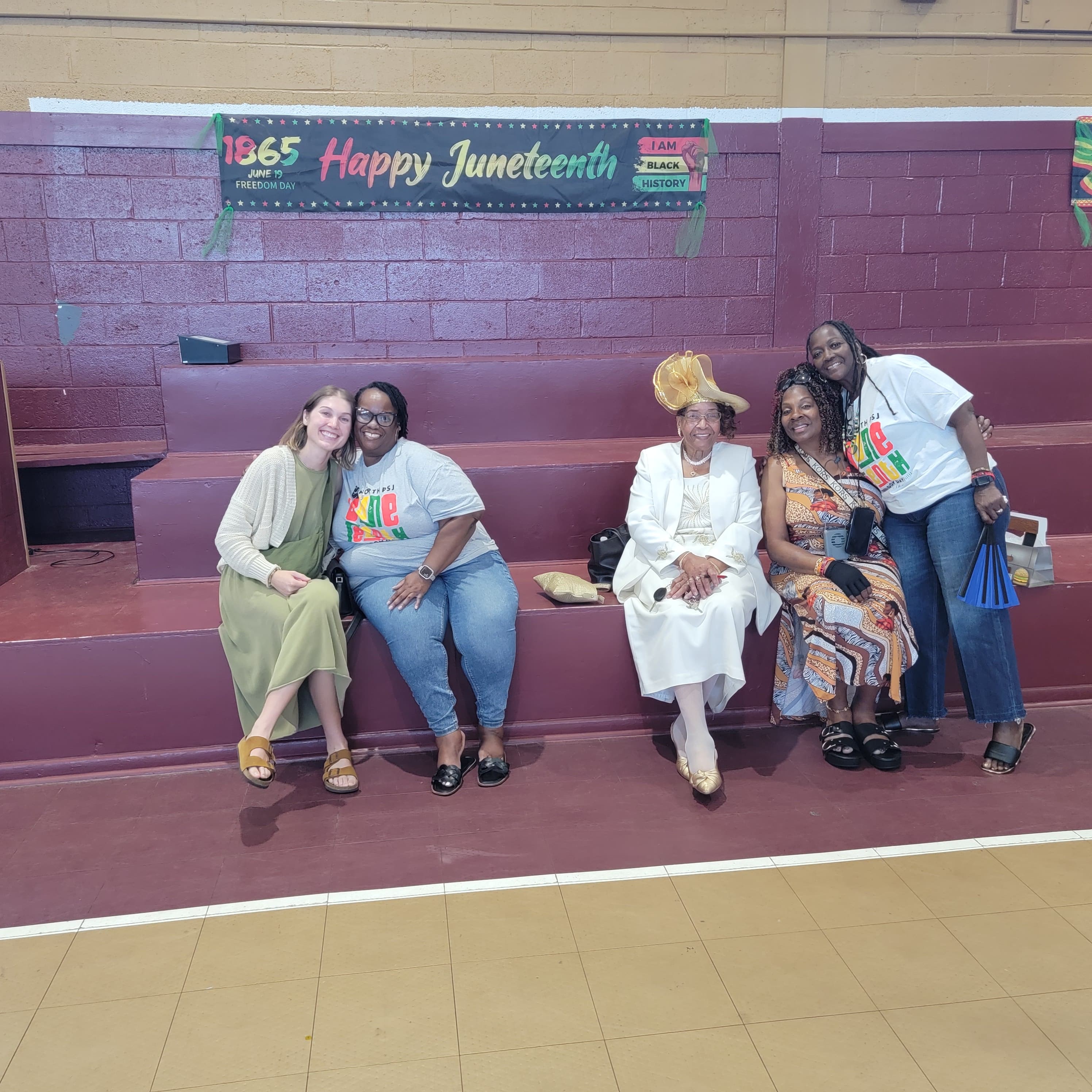 Community members gathered in front of a Happy Juneteenth banner at Washington High School