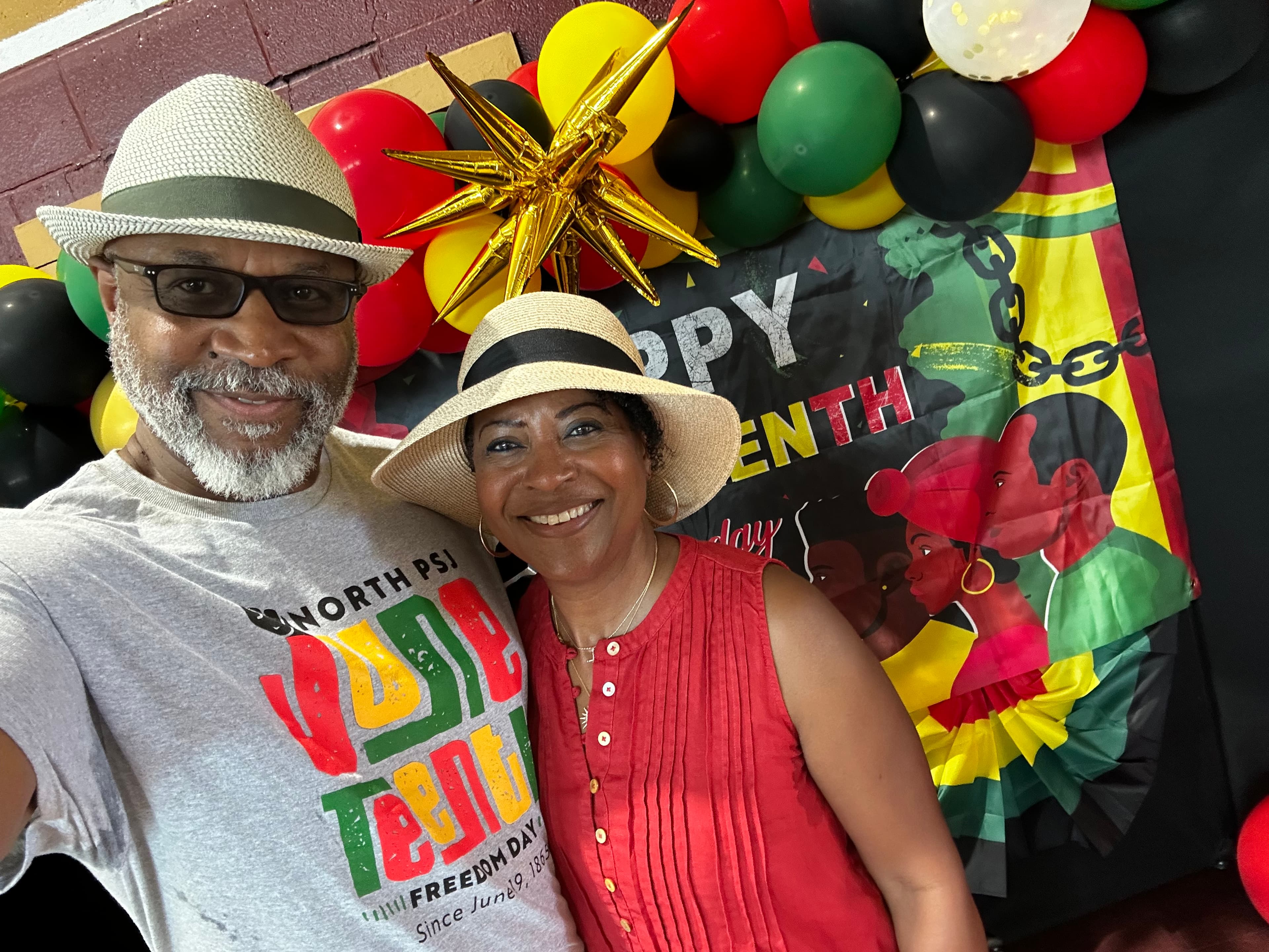 Community members posing at the Juneteenth photo booth with a Happy Juneteenth backdrop